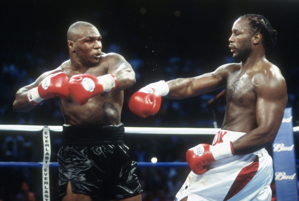 Mike Tyson throws a left hook towards Lennox Lewis during their 2002 bout