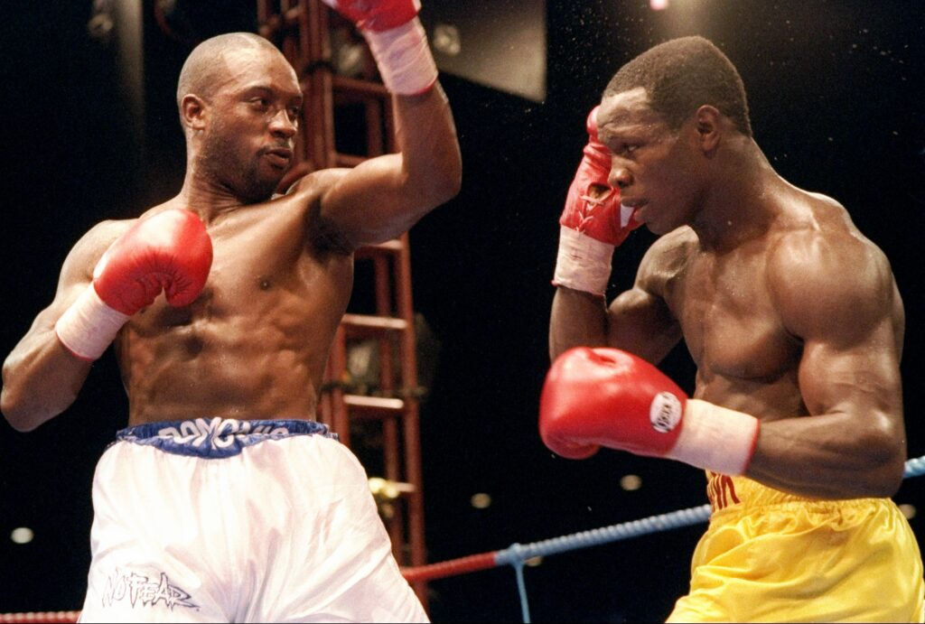 Chris Eubank blocks a punch from Nigel Benn during their 1993 championship rematch at Old Trafford in Manchester