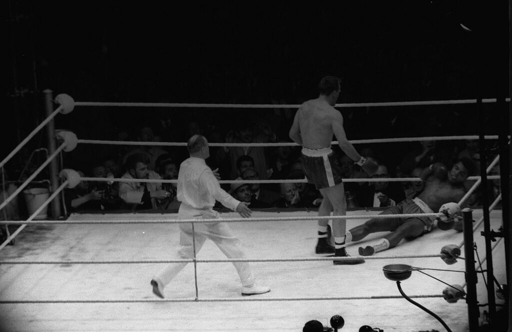 Henry Cooper stands over Muhammad Ali after knocking him down in their fight at Wembley Stadium