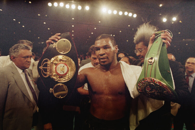 (Original Caption) 8/1/1987-Las Vegas, NVMike Tyson holds up the heavyweight belts for the WBA (l) and WBC championships. Tyson won a unanimous dec...